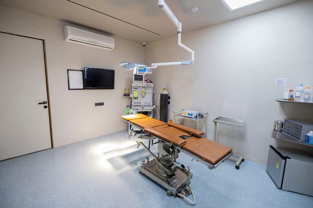 A surgical room with an operating chair and overhead light
