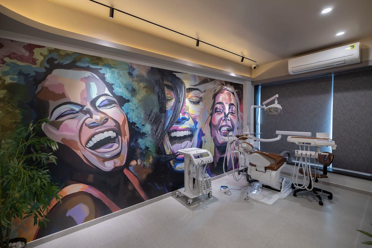 The Dental House નો સારવાર ખંડ — પાછળની દીવાલ પર ચિત્રકામ, દિવસના અજવાળામાં ખુરશી અને સાધનો