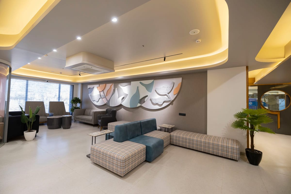 A waiting lounge with a teal sofa beneath a painted mural